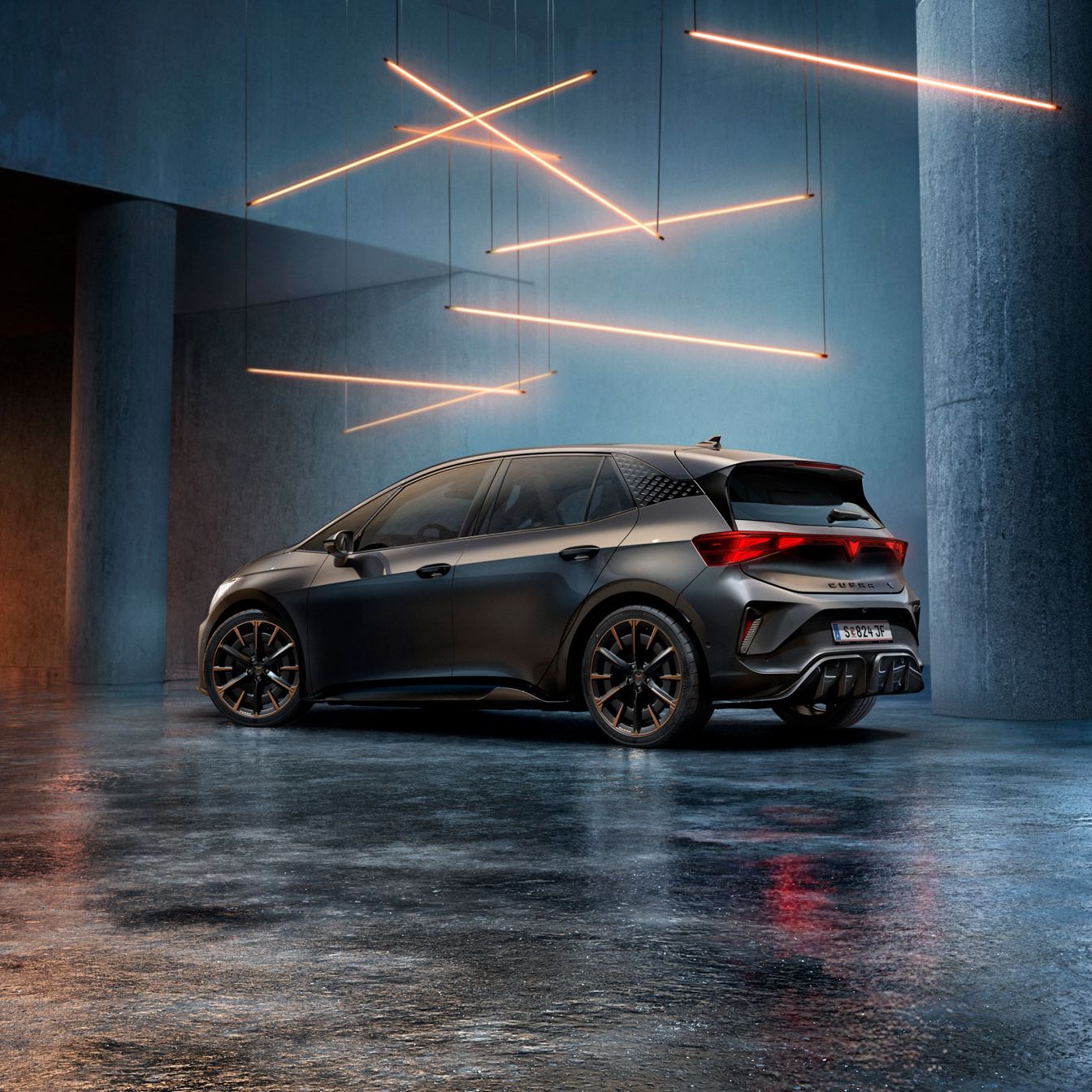 Ein CUPRA Born steht in einem stilvoll beleuchteten, industriellen Raum mit Betonwänden und -säulen. Von der Decke hängen mehrere lineare Lichtquellen, die ein elegantes Ambiente schaffen. Das Fahrzeug ist rückseitig zu sehen und reflektiert das Licht auf dem glänzenden Boden.