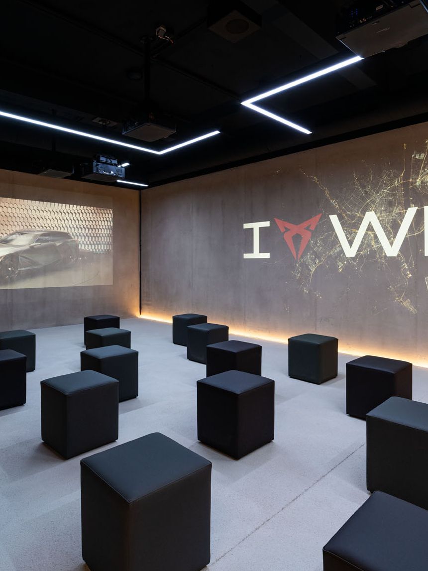 Raum mit Würfel-Sesseln und I CUPRA Wien Logo an der Wand