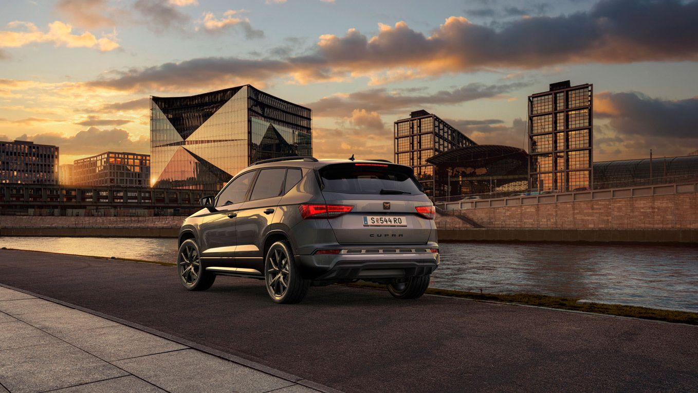 Heckansicht des CUPRA Ateca SUVs bei Sonnenuntergang, mit Fokus auf den neuen, niedrigeren Frontgrill mit Luftkappen und den neuen Heckdiffusor, die beide das äußere Design verstärken und die Aerodynamik optimieren.