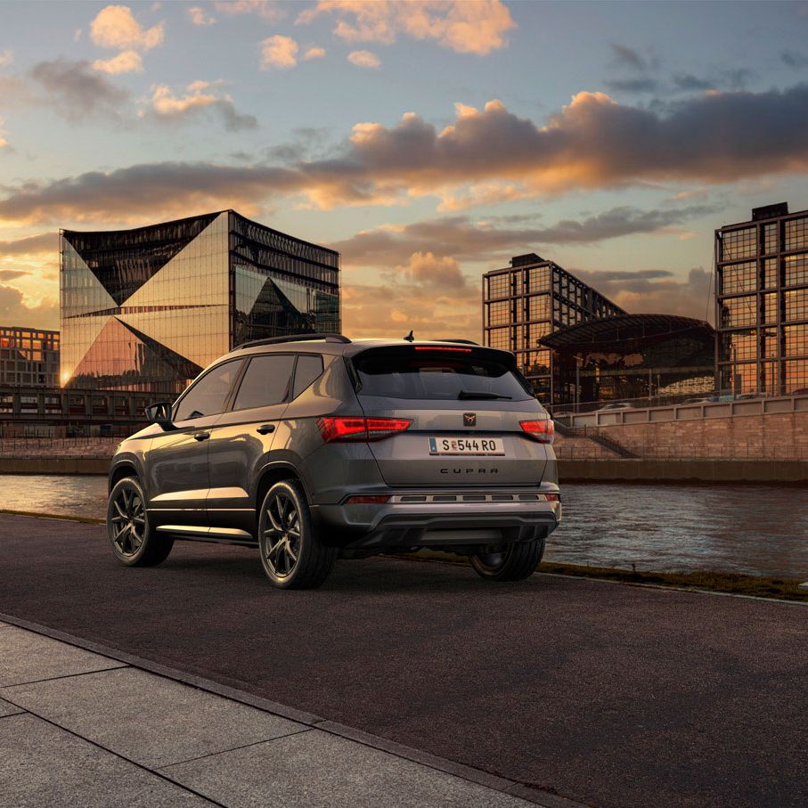 Heckansicht des CUPRA Ateca SUVs bei Sonnenuntergang, mit Fokus auf den neuen, niedrigeren Frontgrill mit Luftkappen und den neuen Heckdiffusor, die beide das äußere Design verstärken und die Aerodynamik optimieren.