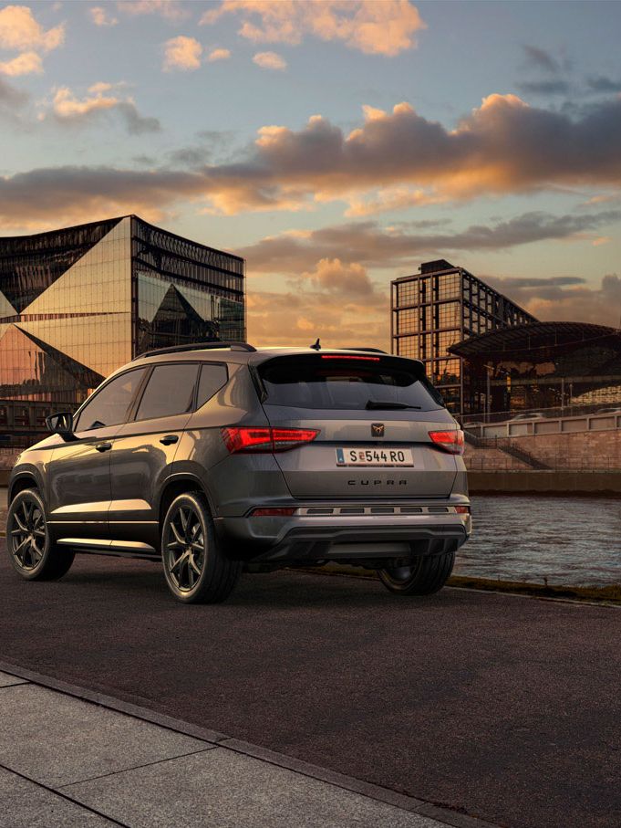 Heckansicht des CUPRA Ateca SUVs bei Sonnenuntergang, mit Fokus auf den neuen, niedrigeren Frontgrill mit Luftkappen und den neuen Heckdiffusor, die beide das äußere Design verstärken und die Aerodynamik optimieren.