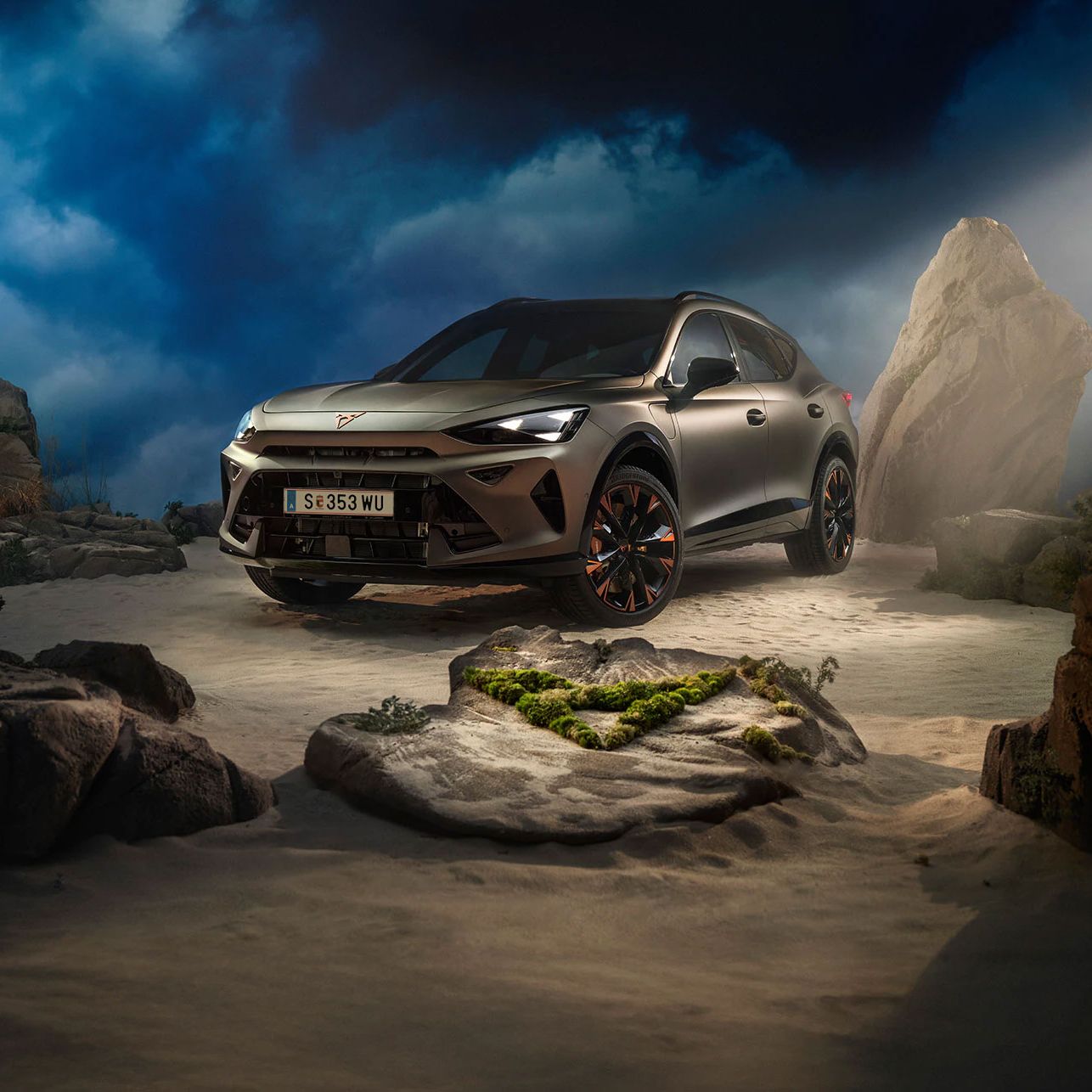 Ein CUPRA Formentor VZ in Bronze steht dramatisch beleuchtet in einer felsigen, nebeligen Landschaft. Eine Lichtstrahl beleuchtet das Fahrzeug und betont seine Konturen. Im Hintergrund sind Felsen und Pflanzen zu sehen.