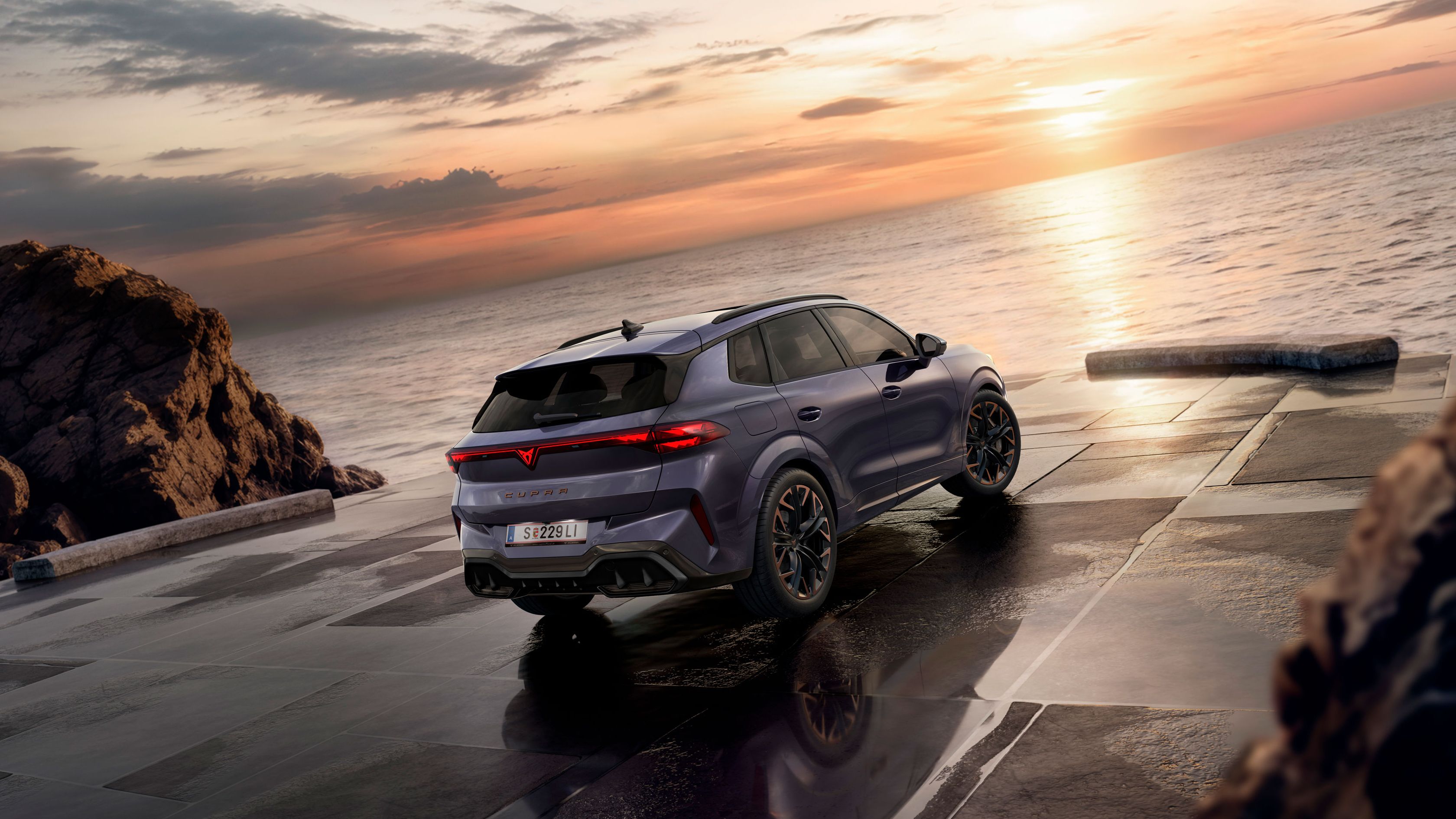 Ein CUPRA Terramar parkt zwischen Klippen am Meer. 