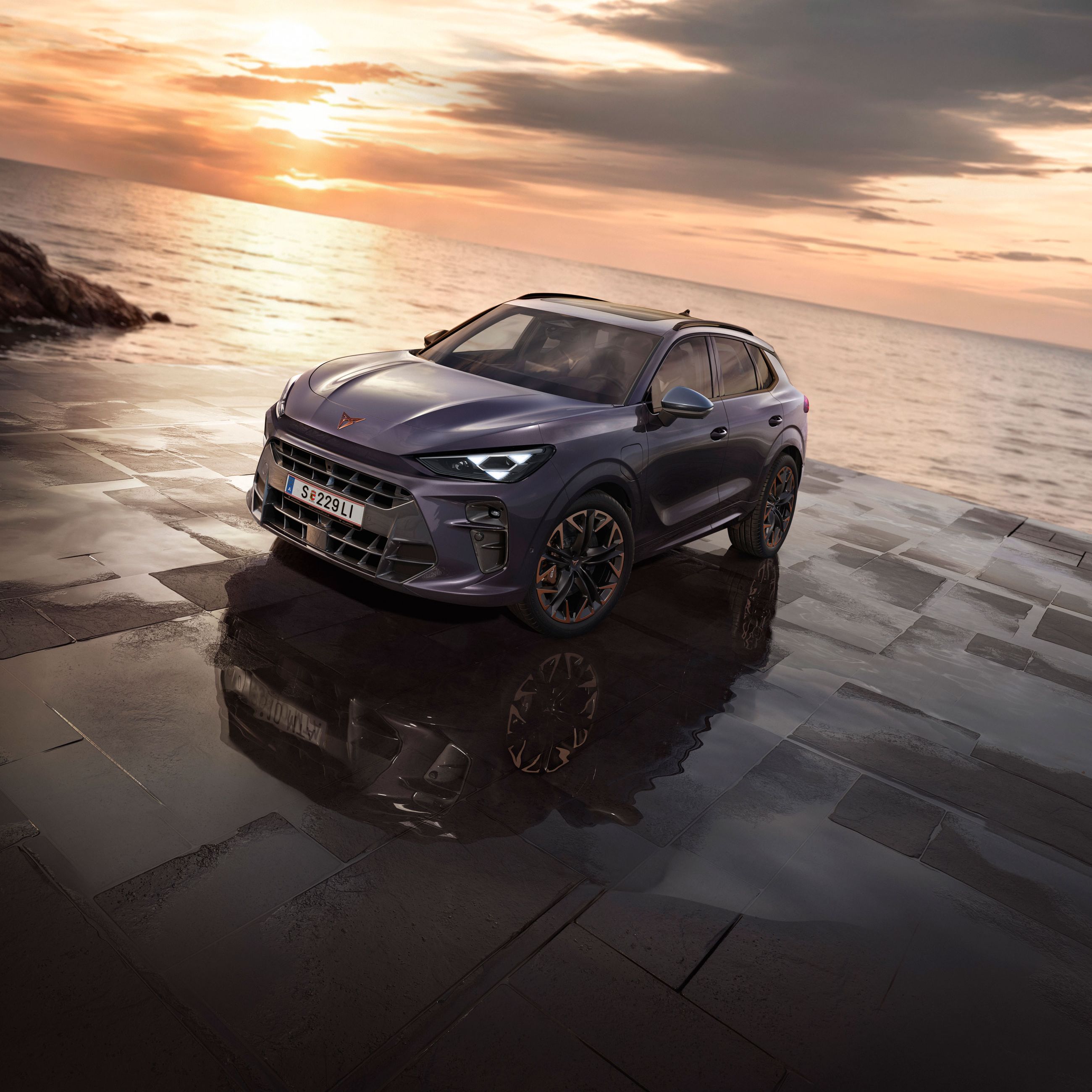 Ein CUPRA Terramar parkt zwischen Felsen an der Meeresküste.