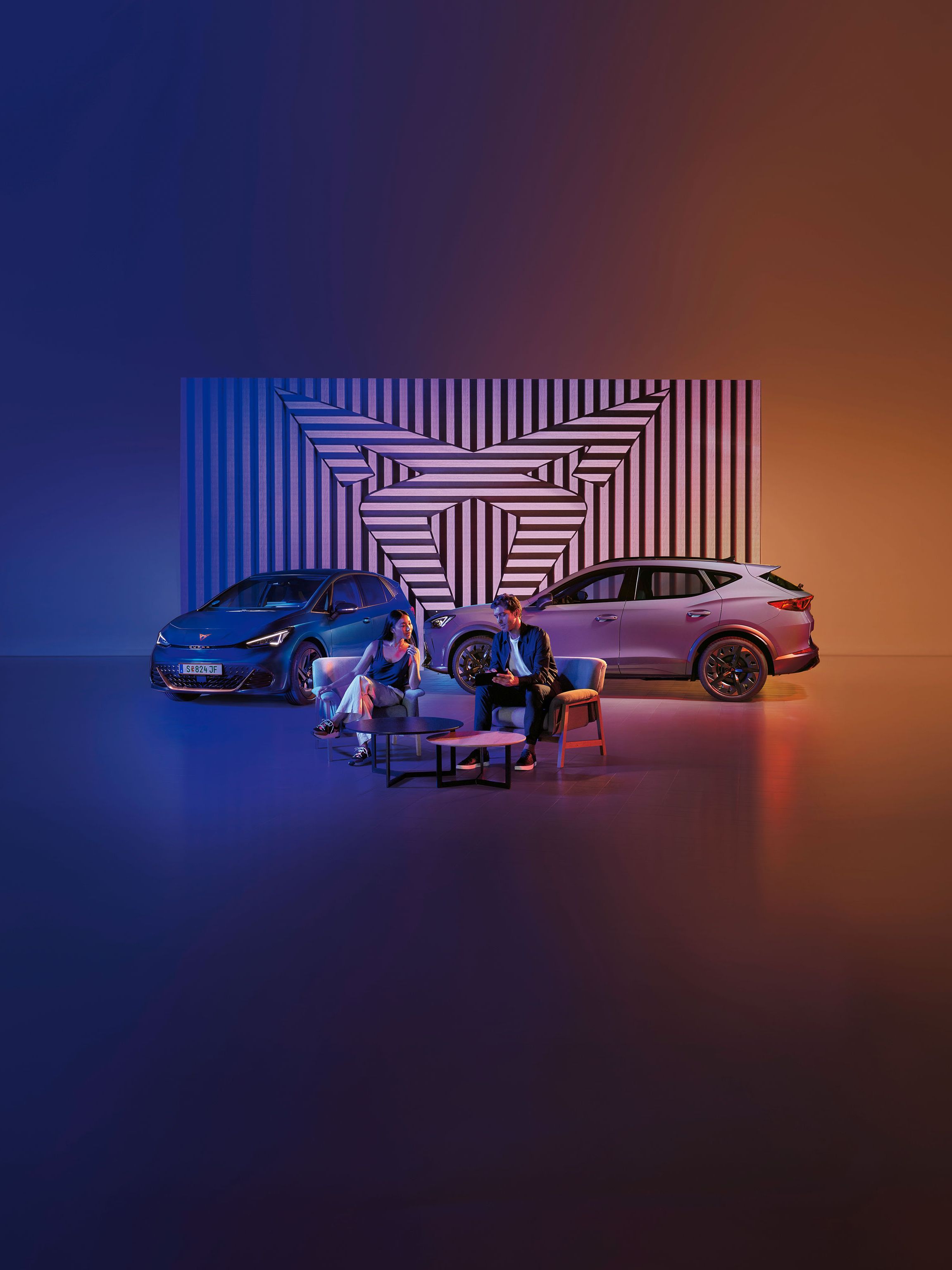Zwei CUPRA Modelle-ein Mann und eine Frau sitzen davor