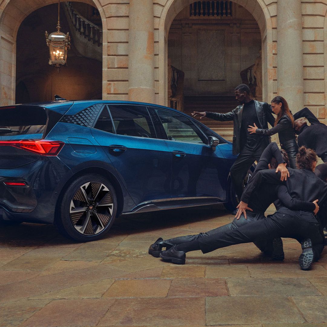 Eine Gruppe von Personen befindet sich neben einem blauen CUPRA Born.