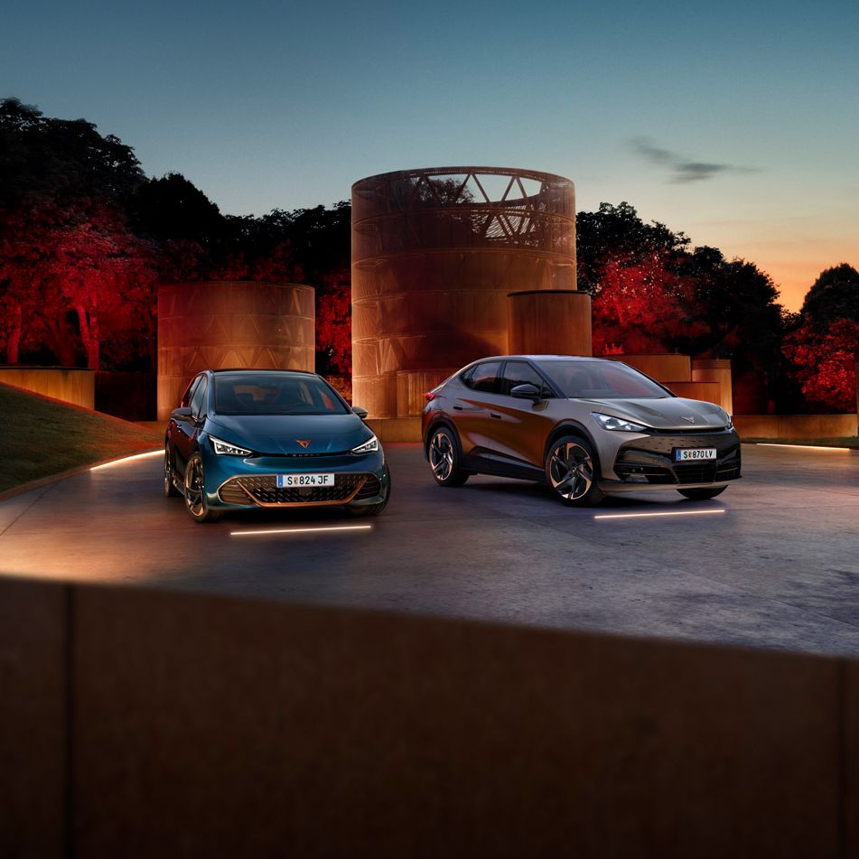 CUPRA Born und Tavascan stehen nebeneinander auf beleuchtetem hintergrund