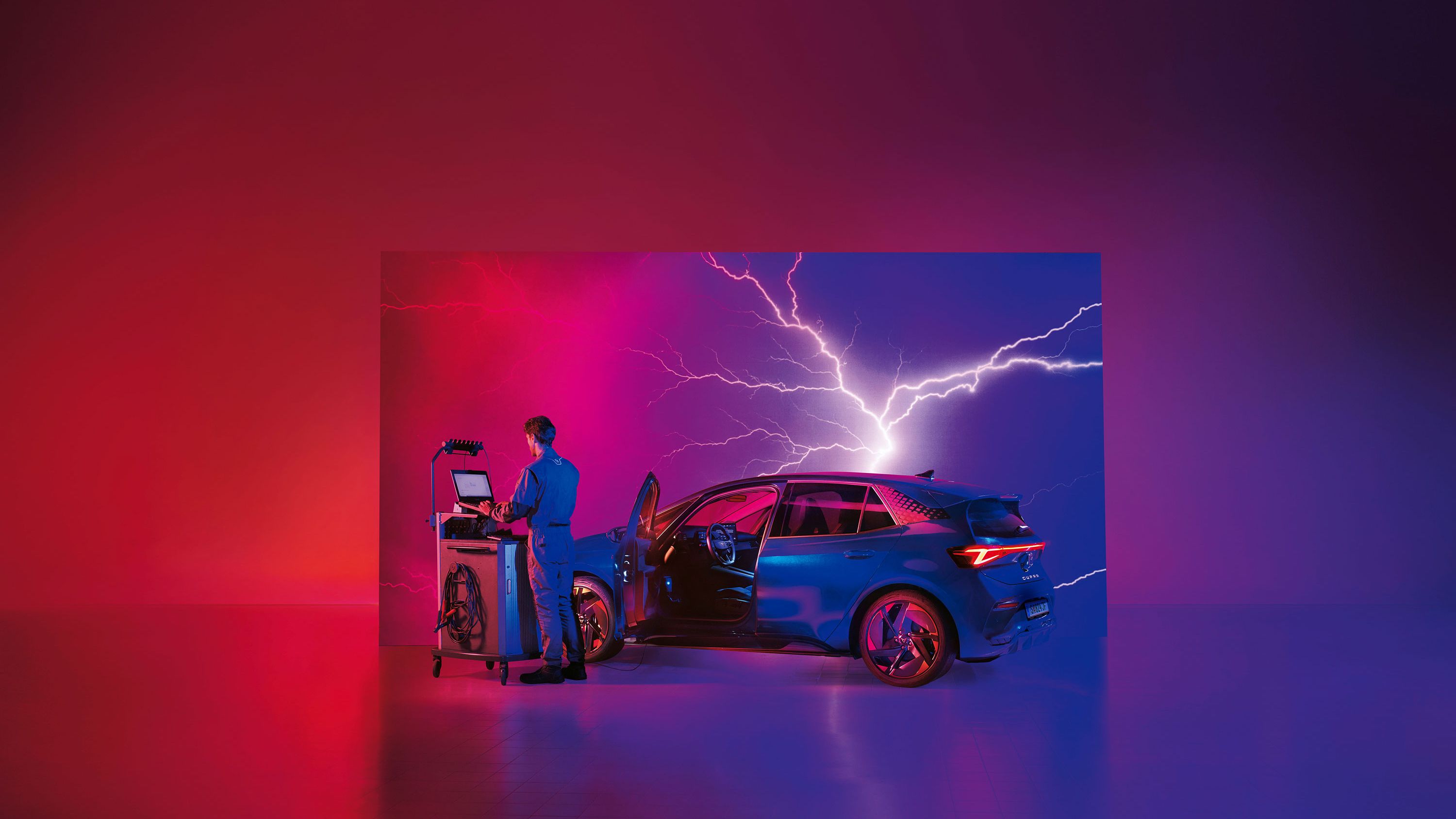 Ein CUPRA Techniker mit Diagnosegräten neben einem CUPRA Born.