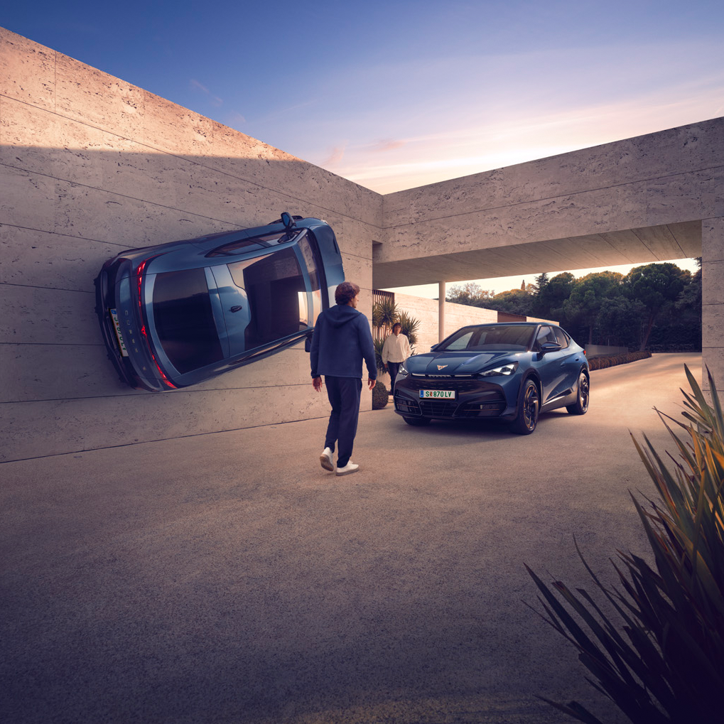 Fotocollage von zwei CUPRA Tavascan bei einem modernen Gebäude, mit einem der Fahrzeuge an der Wand und dem zweiten unter einer Durchfahrt. Zwei Männer bewegen sich zwischen den Fahrzeugen.