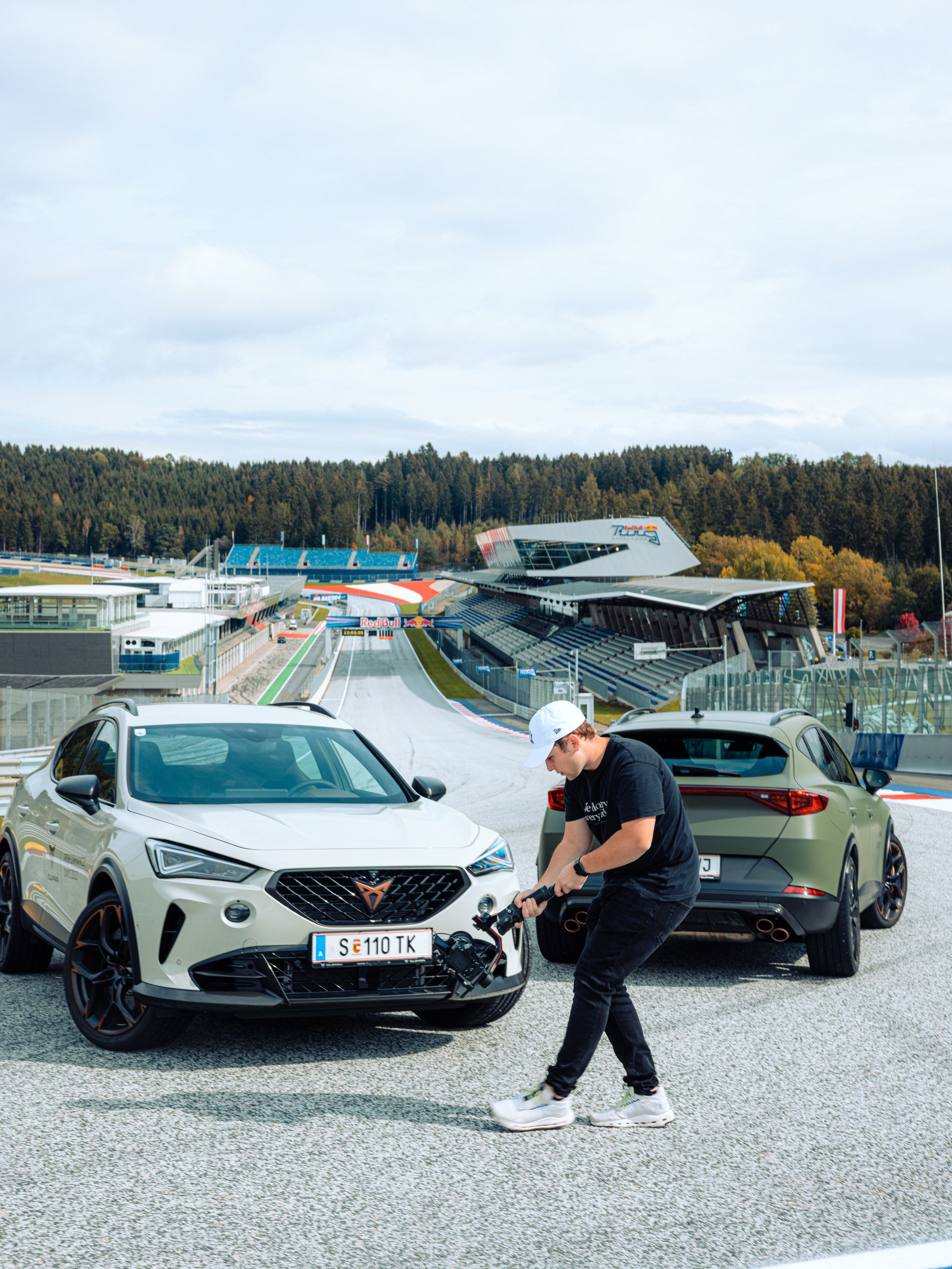 Phillipp Bach vor einem weißen und einem grünen CUPRA Formentor.