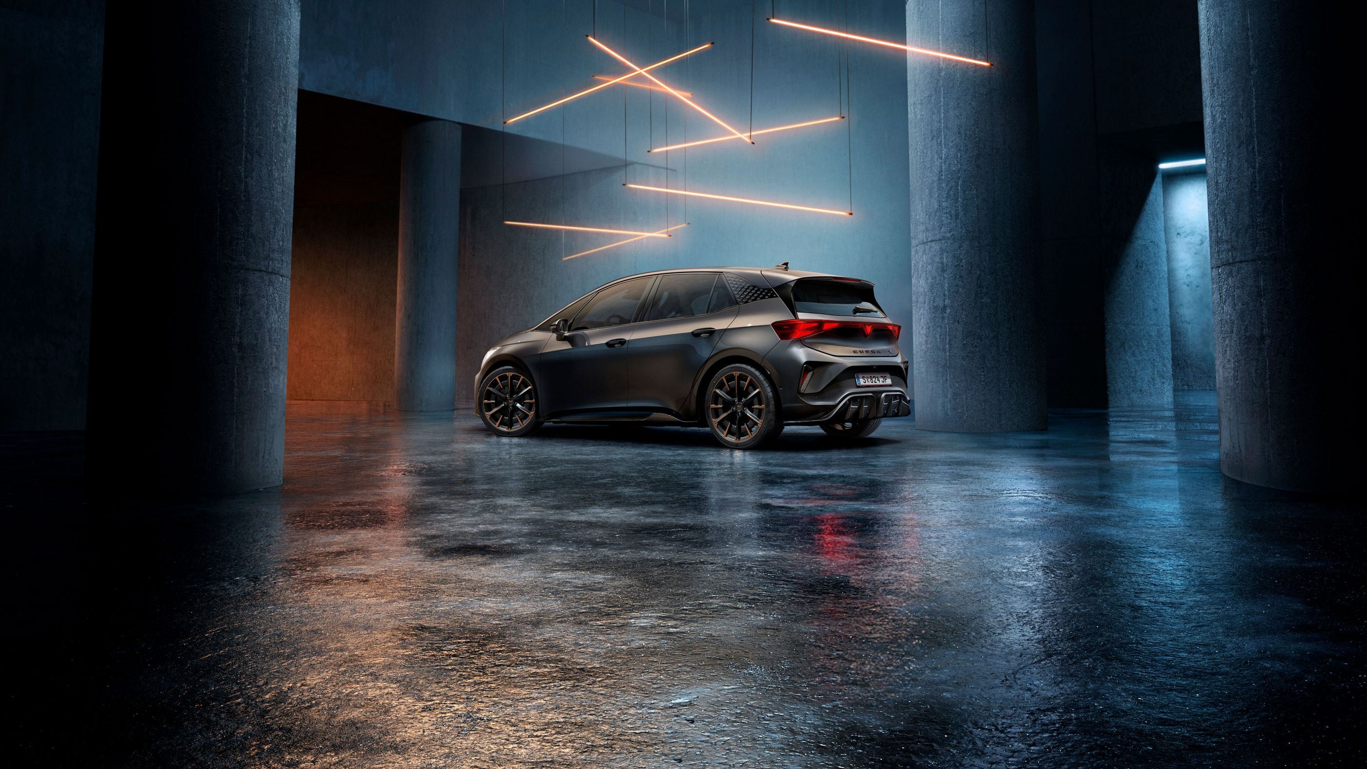 Ein CUPRA Born steht in einem stilvoll beleuchteten, industriellen Raum mit Betonwänden und -säulen. Von der Decke hängen mehrere lineare Lichtquellen, die ein elegantes Ambiente schaffen. Das Fahrzeug ist rückseitig zu sehen und reflektiert das Licht auf dem glänzenden Boden.