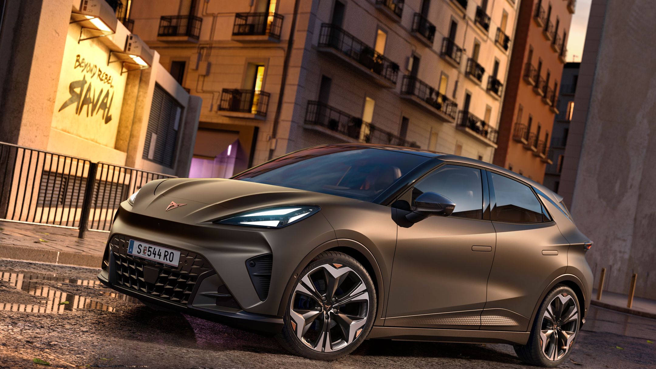 CUPRA Raval in Mangan-Grün steht auf einer Straße in urbaner Umgebung