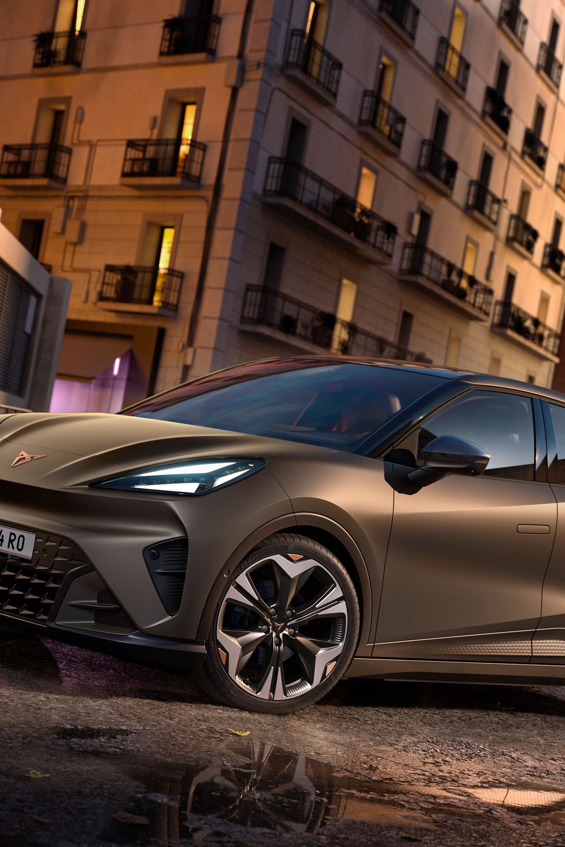 CUPRA Raval in Mangan-Grün steht auf einer Straße in urbaner Umgebung