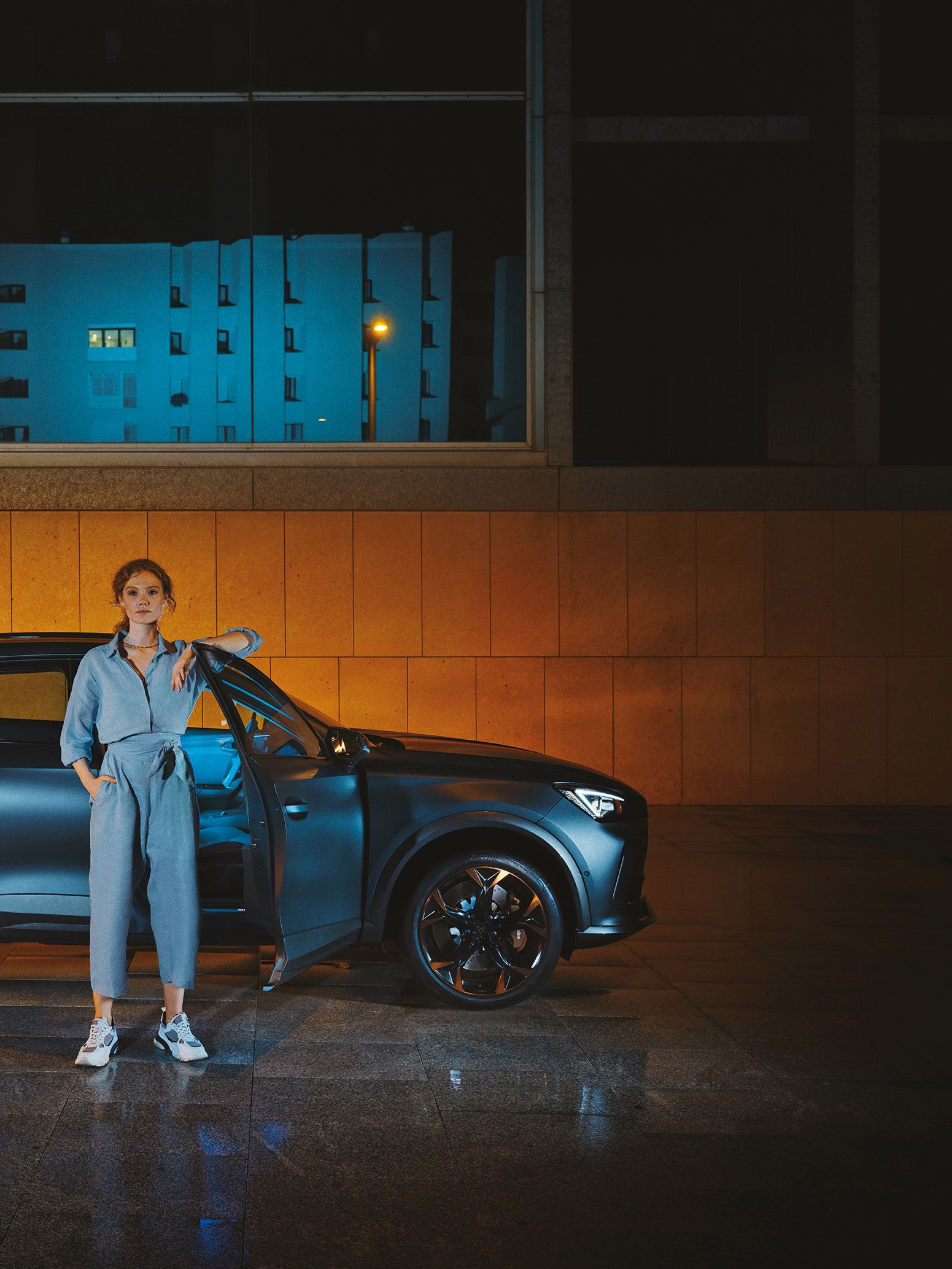CUPRA Formentor bei Nacht, eine Frau steht davor