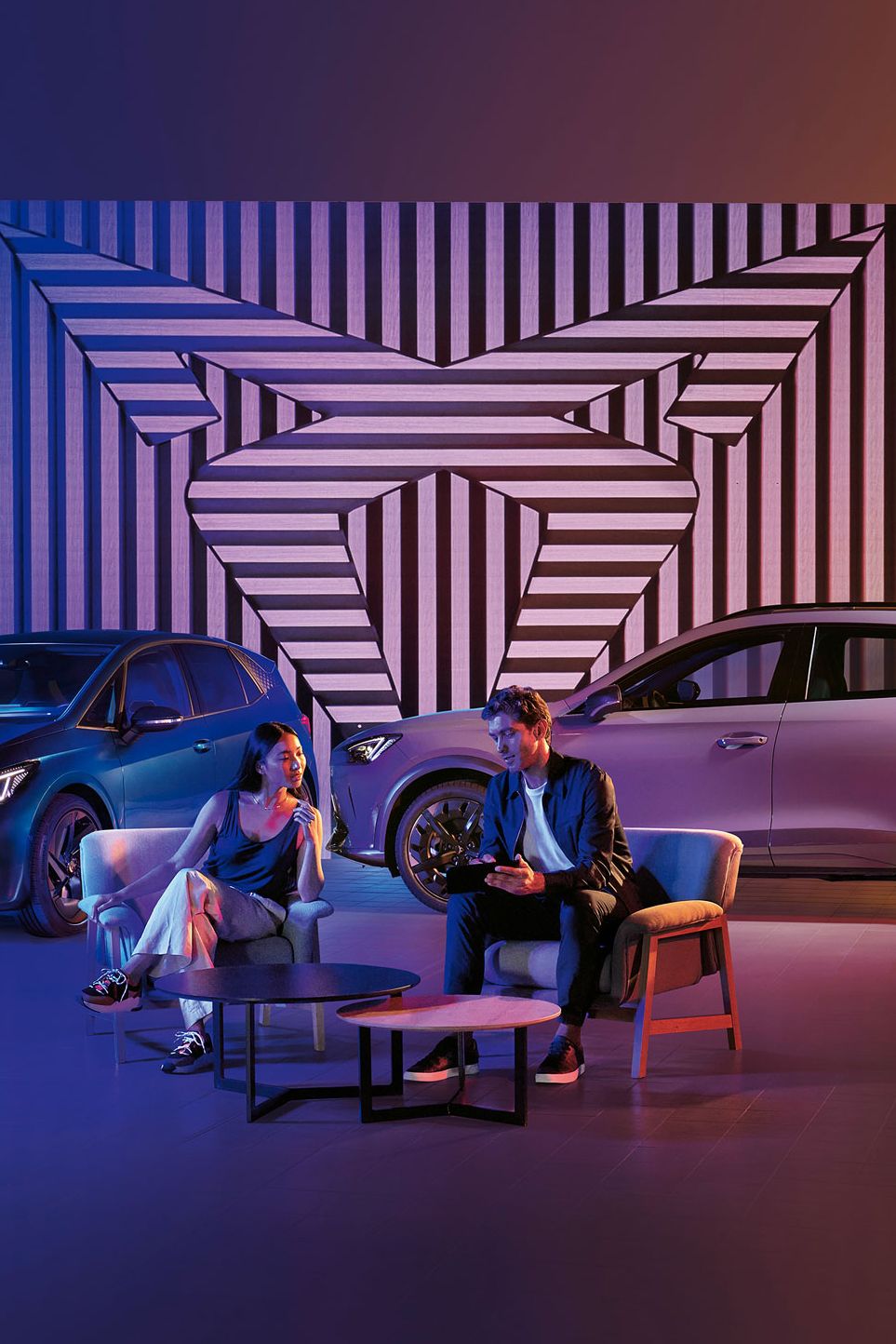 Zwei CUPRA Modelle-ein Mann und eine Frau sitzen davor