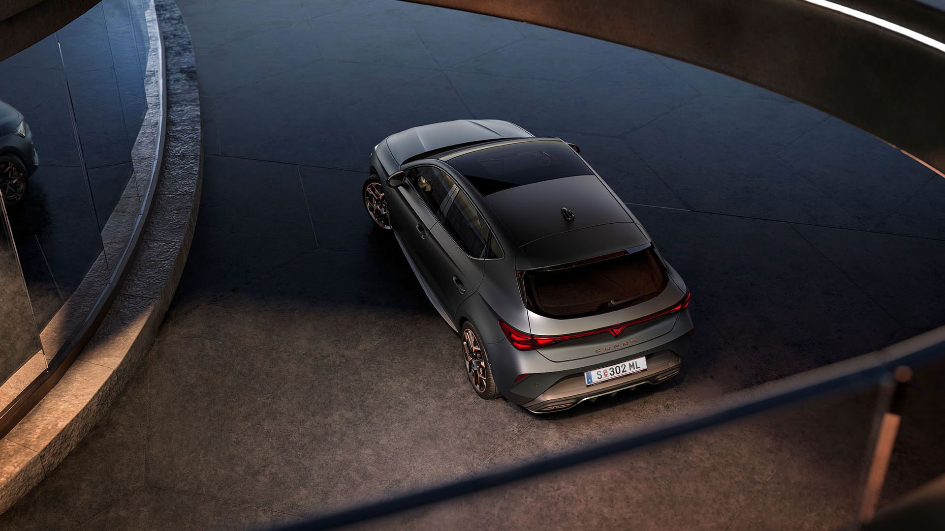 Blick von oben auf einen grauen CUPRA Leon in einem Parkhaus.