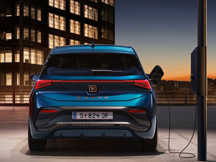 Heckansicht eines blauen CUPRA Born beim Ladevorgang.