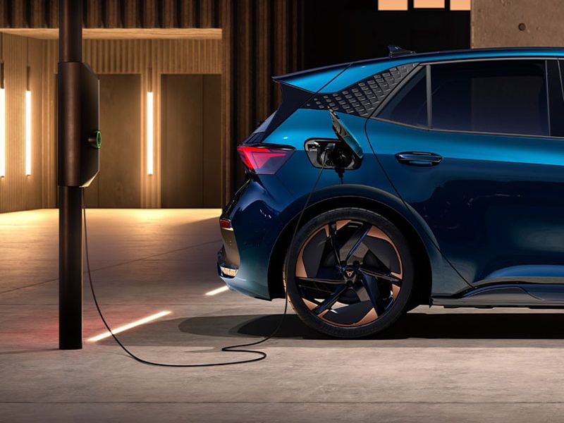 Seitliche hintere Ansicht eine CUPRA Born beim Ladevorgang.