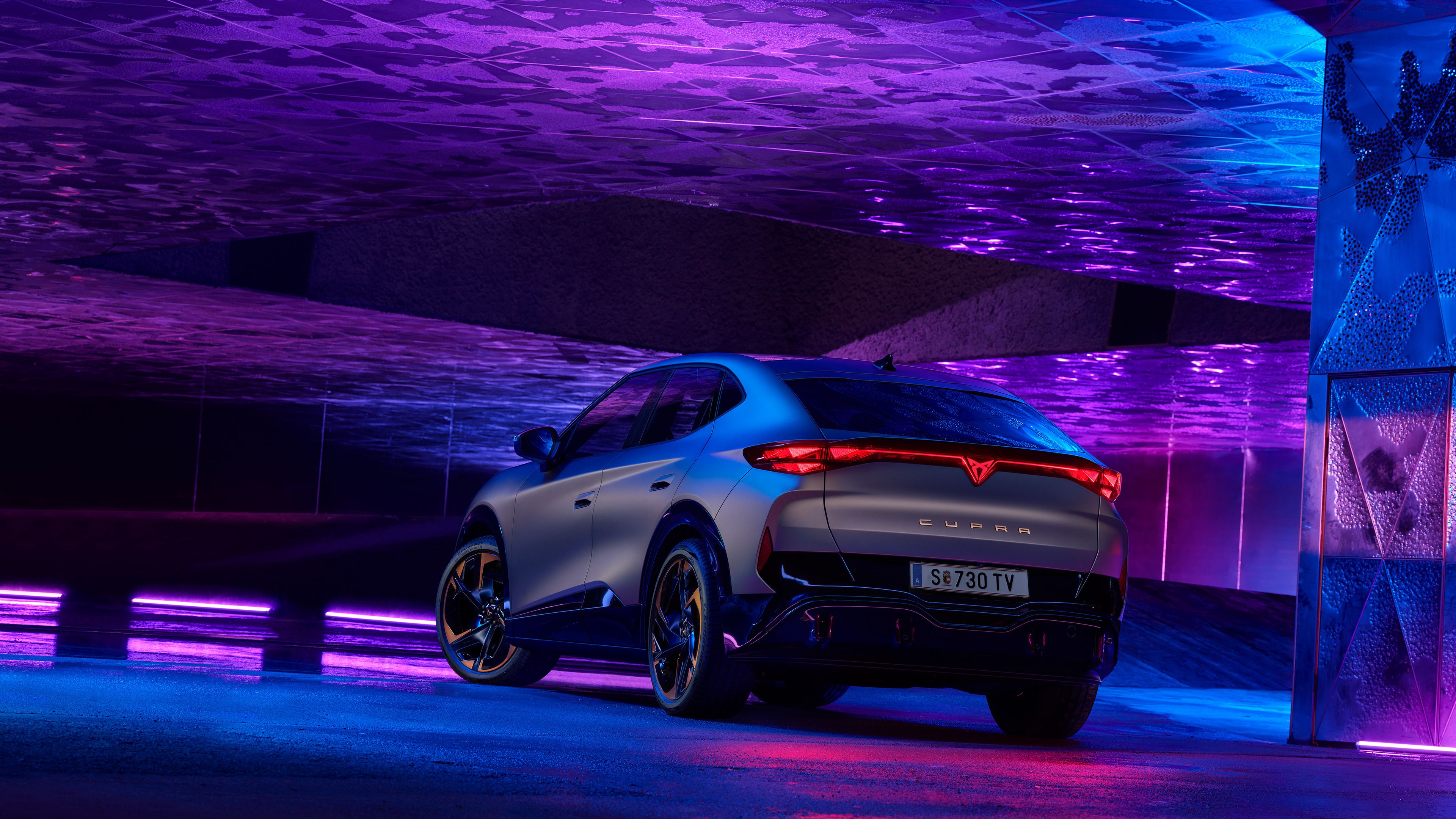 CUPRA Tascavan Heckansicht in blauem und lila Licht