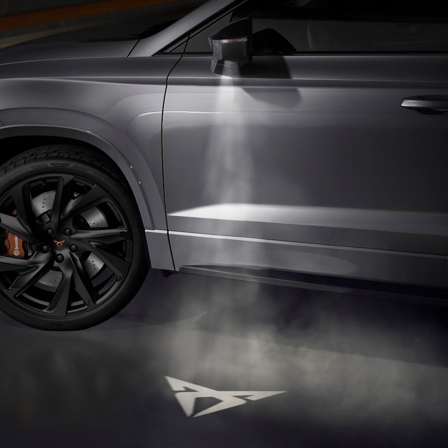 Das CUPRA-Logo, das vom CUPRA Ateca auf den Boden projiziert wird, und die Verbindung mit dem CUPRA Tribe symbolisiert.