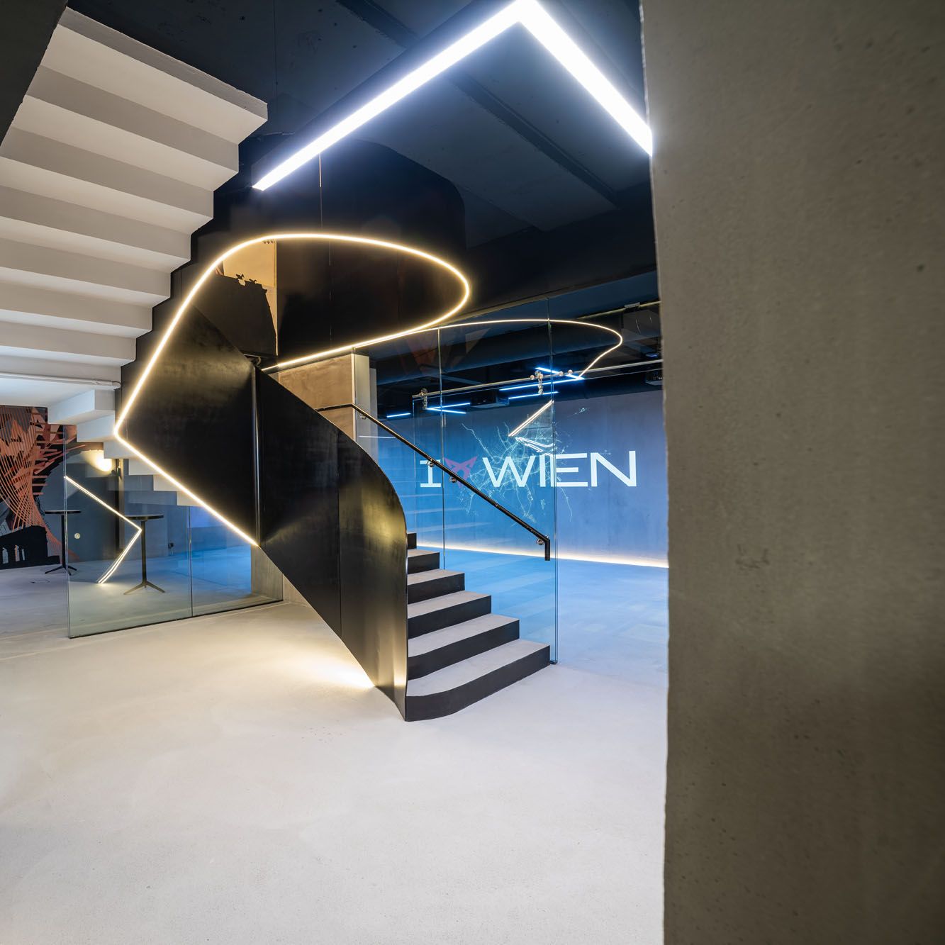 CUPRA City Garage Innenraum. Stiegen und Glaswand