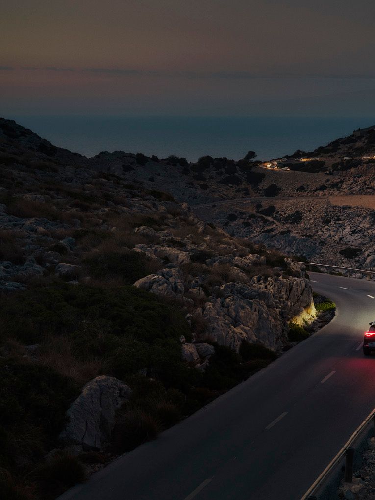 Ein CUPRA Formentor bei Nacht auf einer gebirgigen Küstenstraße
