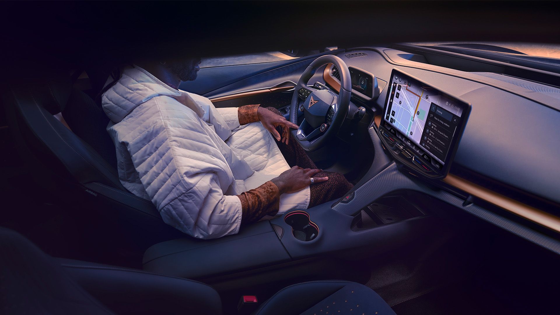 Ein Mann sitzt am Fahrersitz eines CUPRA Tavascan.