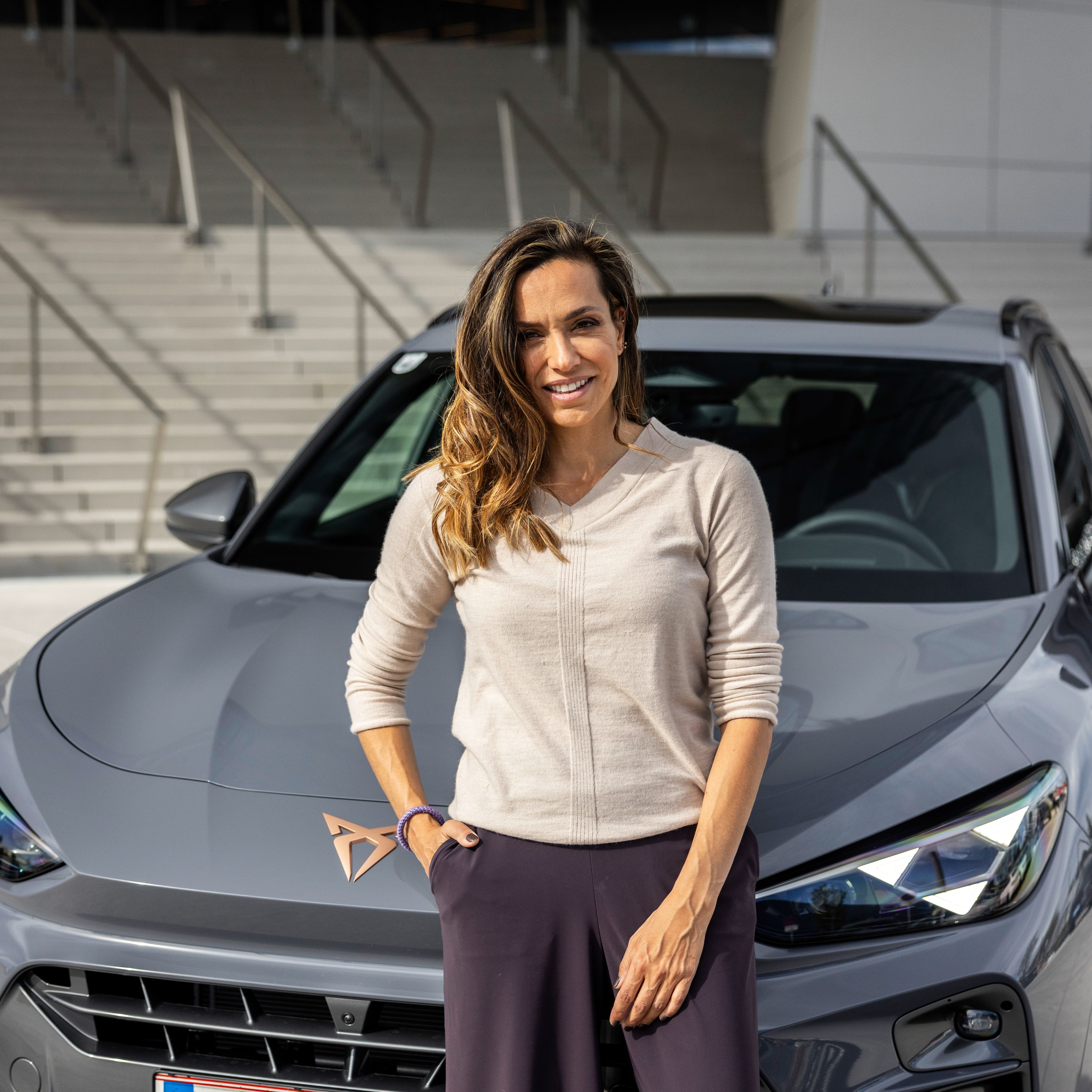 Andrea Schlager vor einem grauen CUPRA Terramar VZ e-Hybrid.