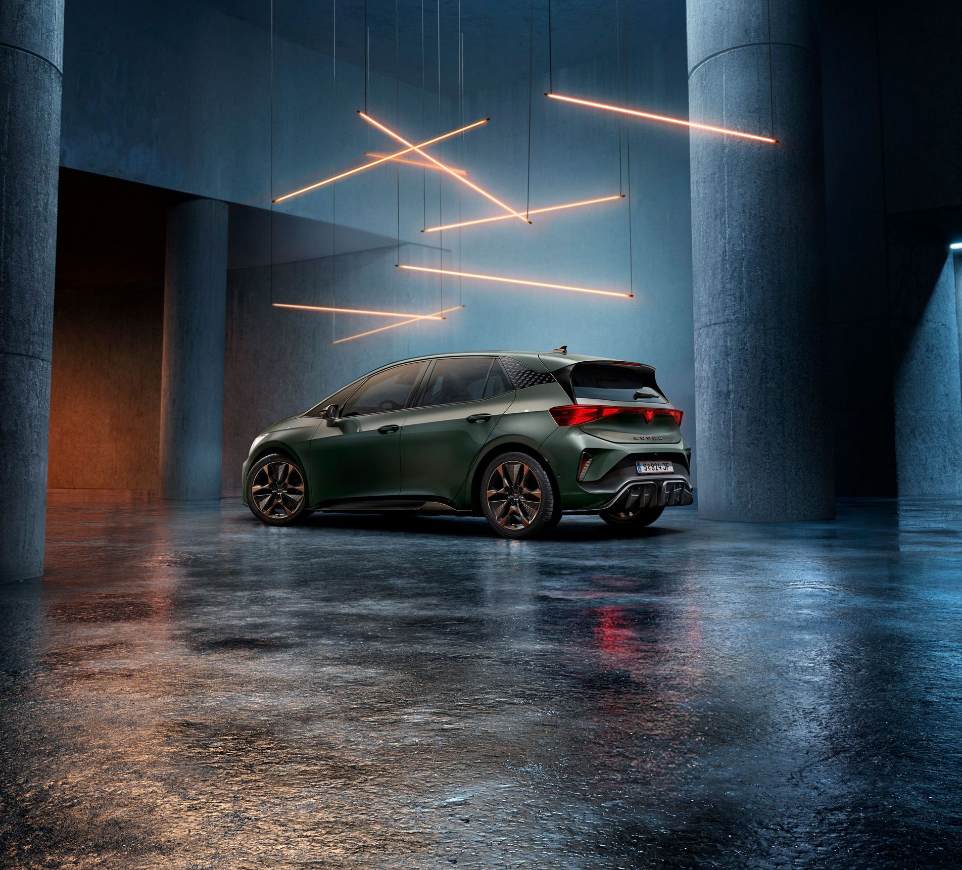 Ein grüner CUPRA Born steht in einem düsteren, industriellen Ambiente mit großen Säulen. Über dem Auto hängen stilvolle, leuchtende LED-Lichter in geometrischen Formen. Der Boden ist glatt und reflektiert das Licht leicht.