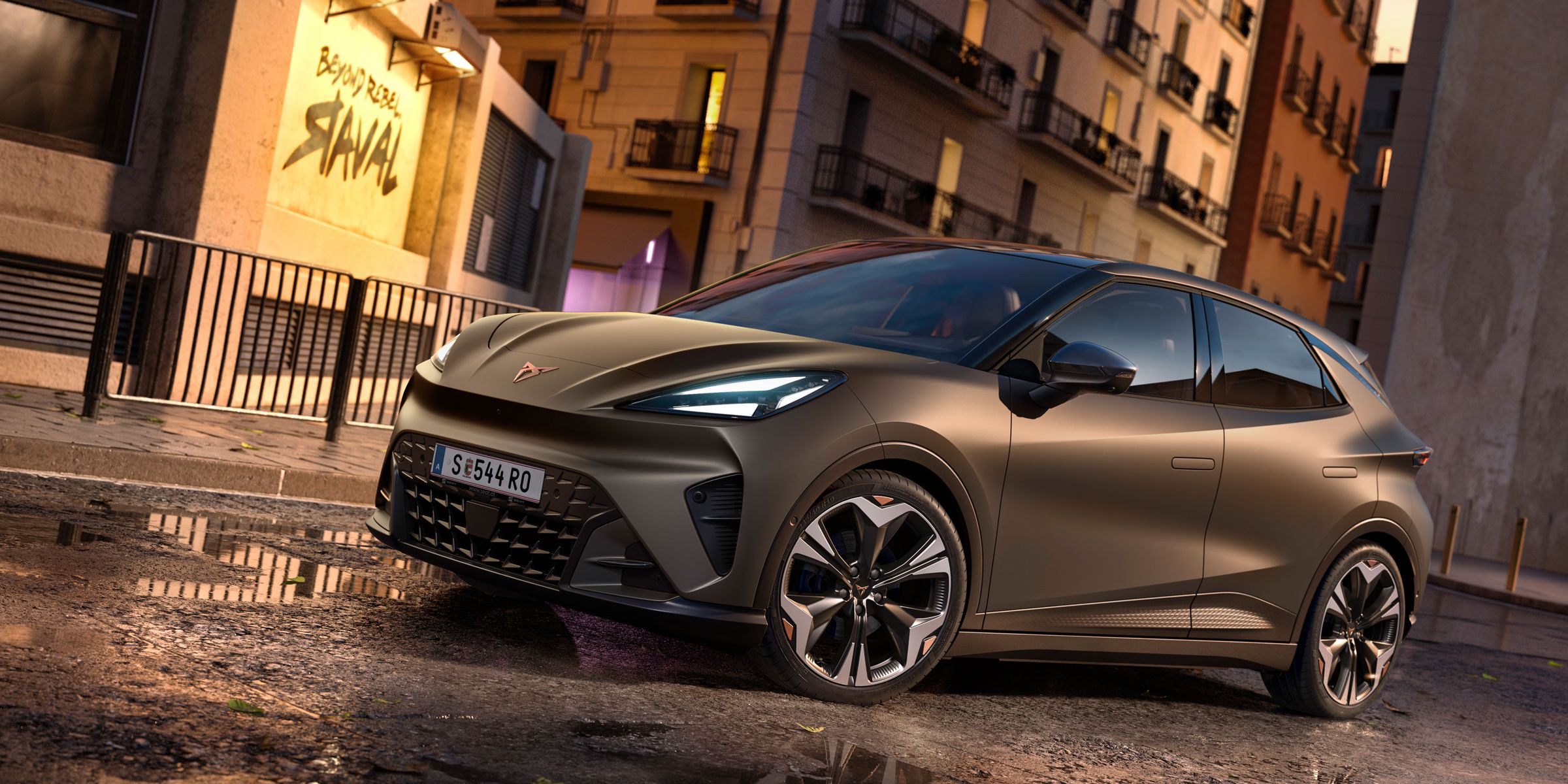 CUPRA Raval in Mangan-Grün steht auf einer Straße in urbaner Umgebung