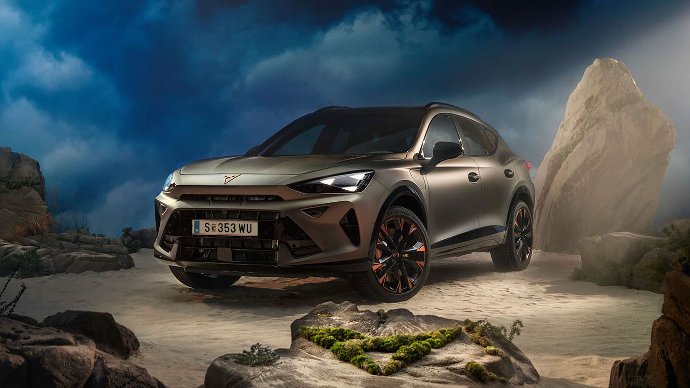 Ein CUPRA Formentor VZ in Bronze steht dramatisch beleuchtet in einer felsigen, nebeligen Landschaft. Eine Lichtstrahl beleuchtet das Fahrzeug und betont seine Konturen. Im Hintergrund sind Felsen und Pflanzen zu sehen.