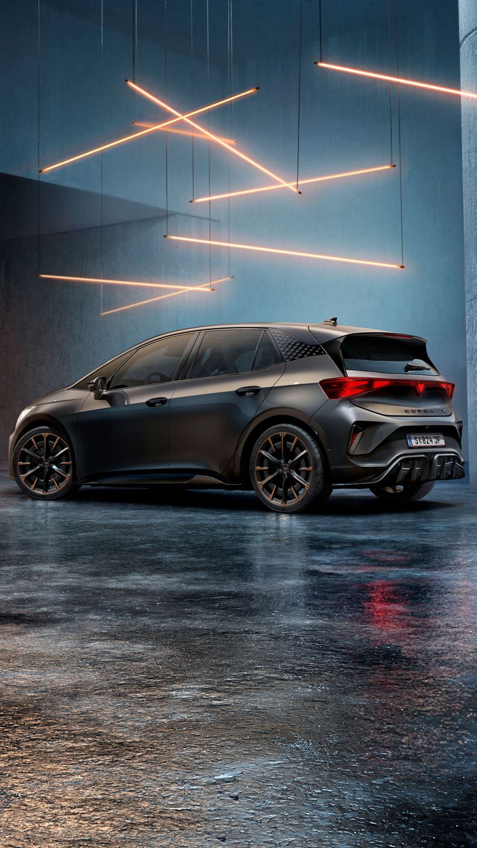 Ein CUPRA Born steht in einem stilvoll beleuchteten, industriellen Raum mit Betonwänden und -säulen. Von der Decke hängen mehrere lineare Lichtquellen, die ein elegantes Ambiente schaffen. Das Fahrzeug ist rückseitig zu sehen und reflektiert das Licht auf dem glänzenden Boden.
