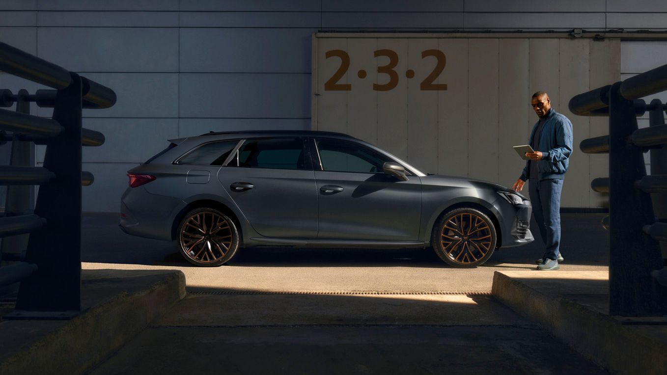 Ein Cupra Techniker mit Tablet neben einem CUPRA Leon SP Kombi.