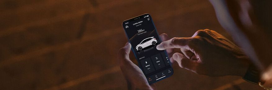 Eine Person sitzt nachts auf Treppenstufen und nutzt CUPRA Connect auf einem Smartphone.