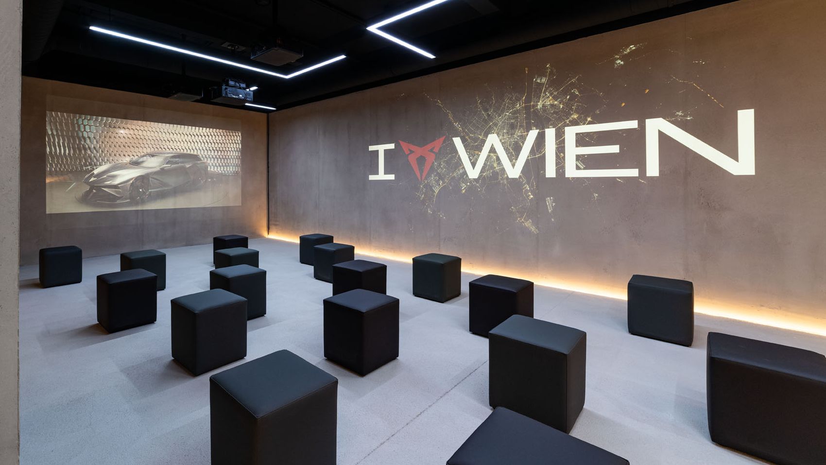 Raum mit Würfel-Sesseln und I CUPRA Wien Logo an der Wand