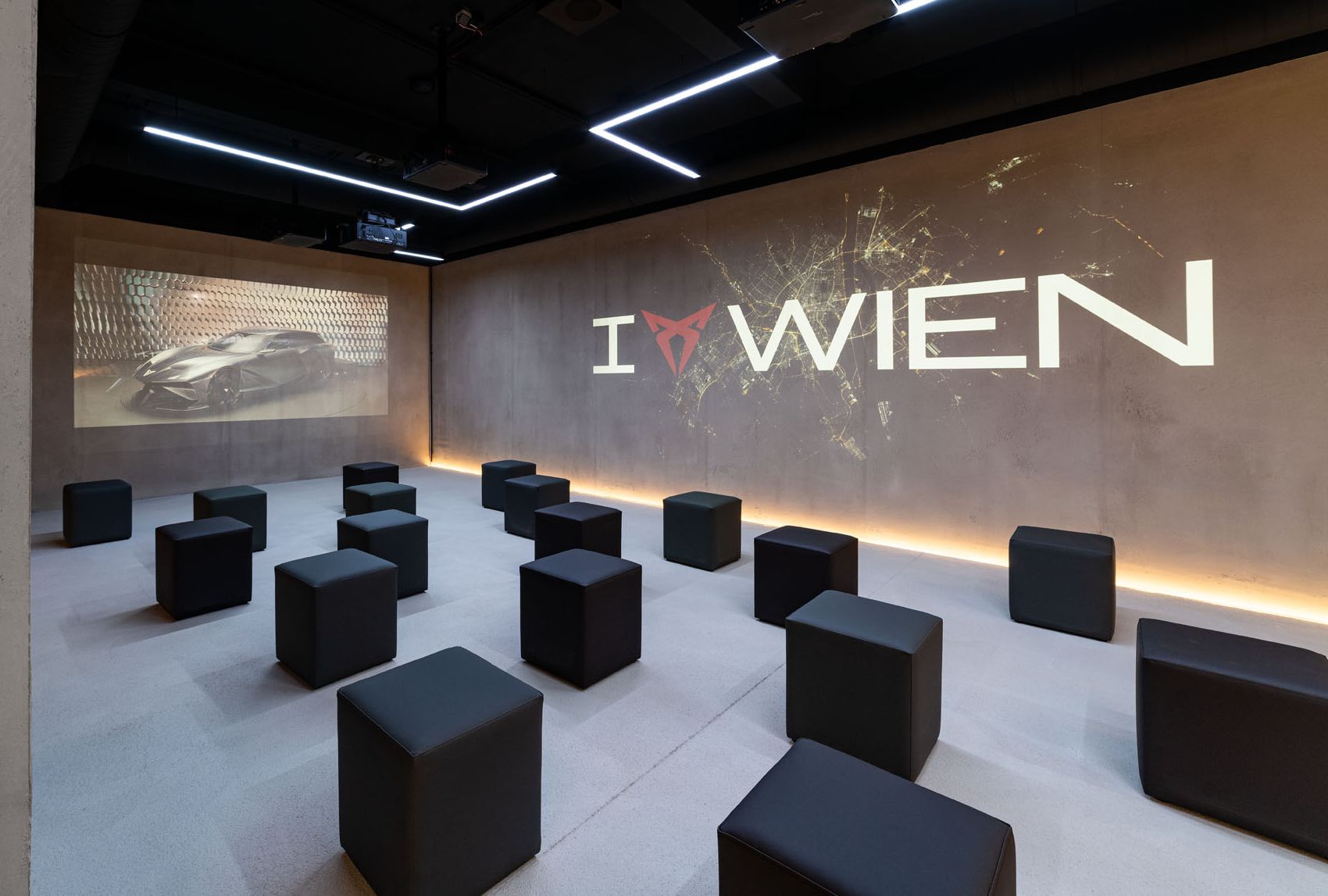 Raum mit Würfel-Sesseln und I CUPRA Wien Logo an der Wand