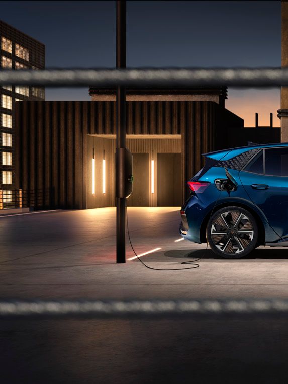 Seitenansicht eines blauen CUPRA Born beim Ladevorgang.