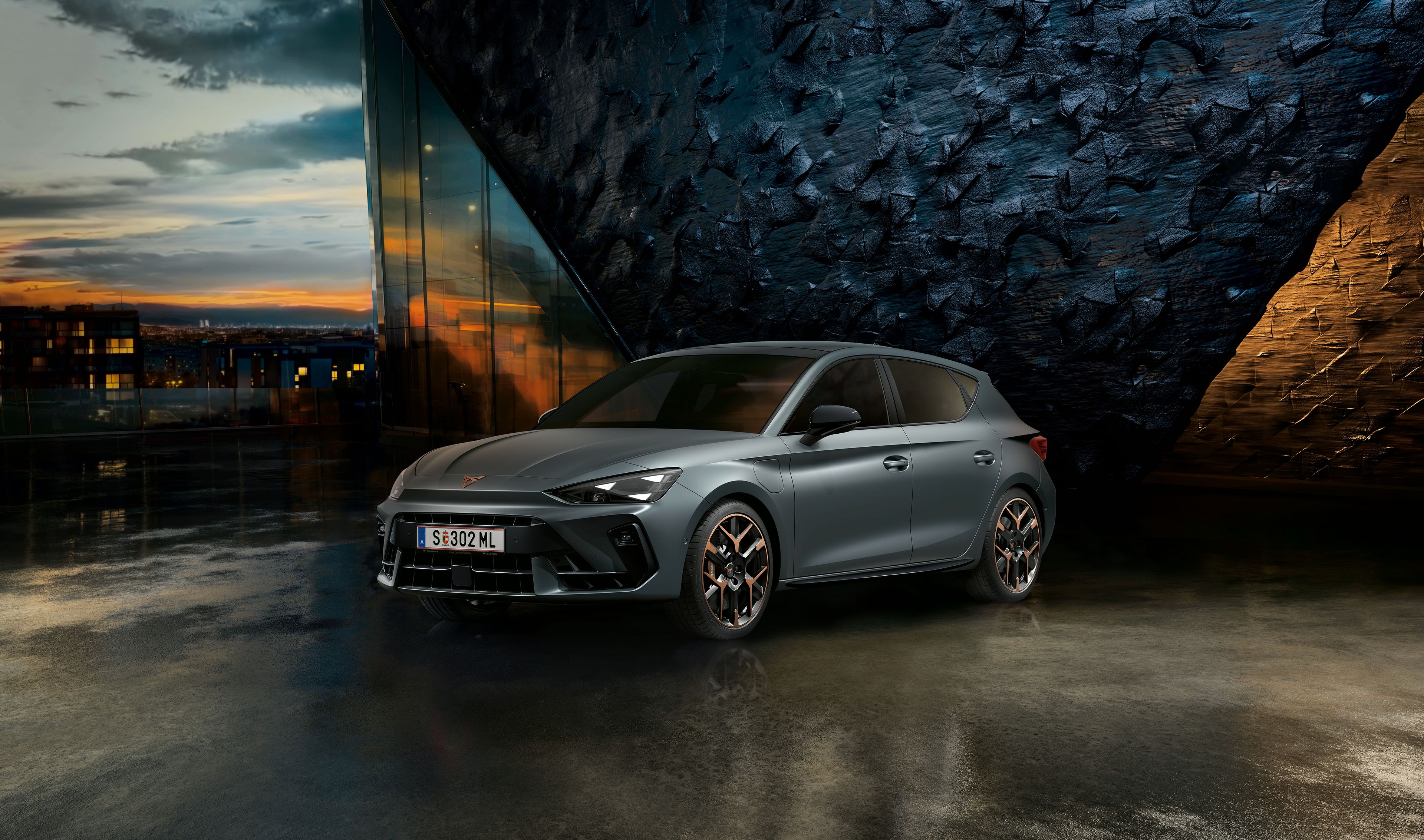 CUPRA Leon vor einer Steinwand bei Sonnenuntergang