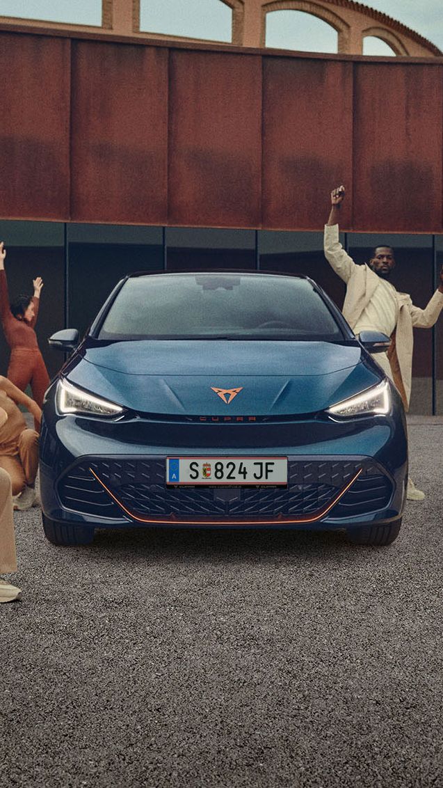Tänzer posieren um einen blauen CUPRA Born.