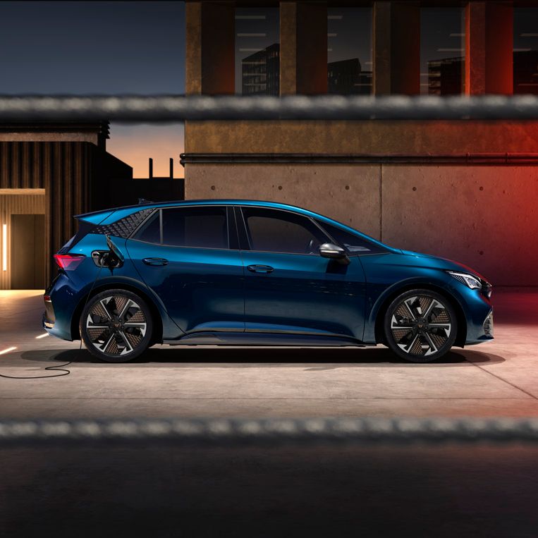 Seitenansicht eines blauen CUPRA Born beim Ladevorgang.