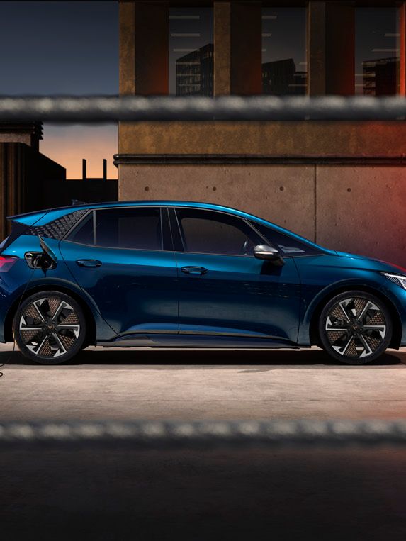 Seitenansicht eines blauen CUPRA Born beim Ladevorgang.