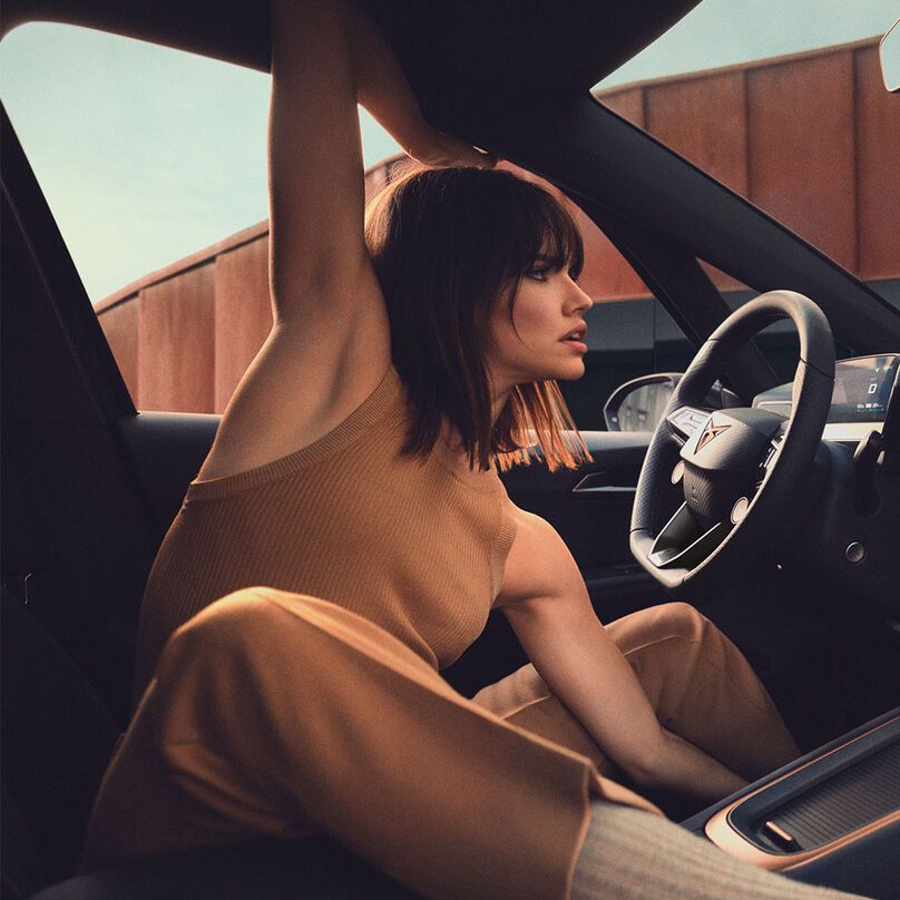 Eine Frau sitz am Fahrersitz eines CUPRA Born.