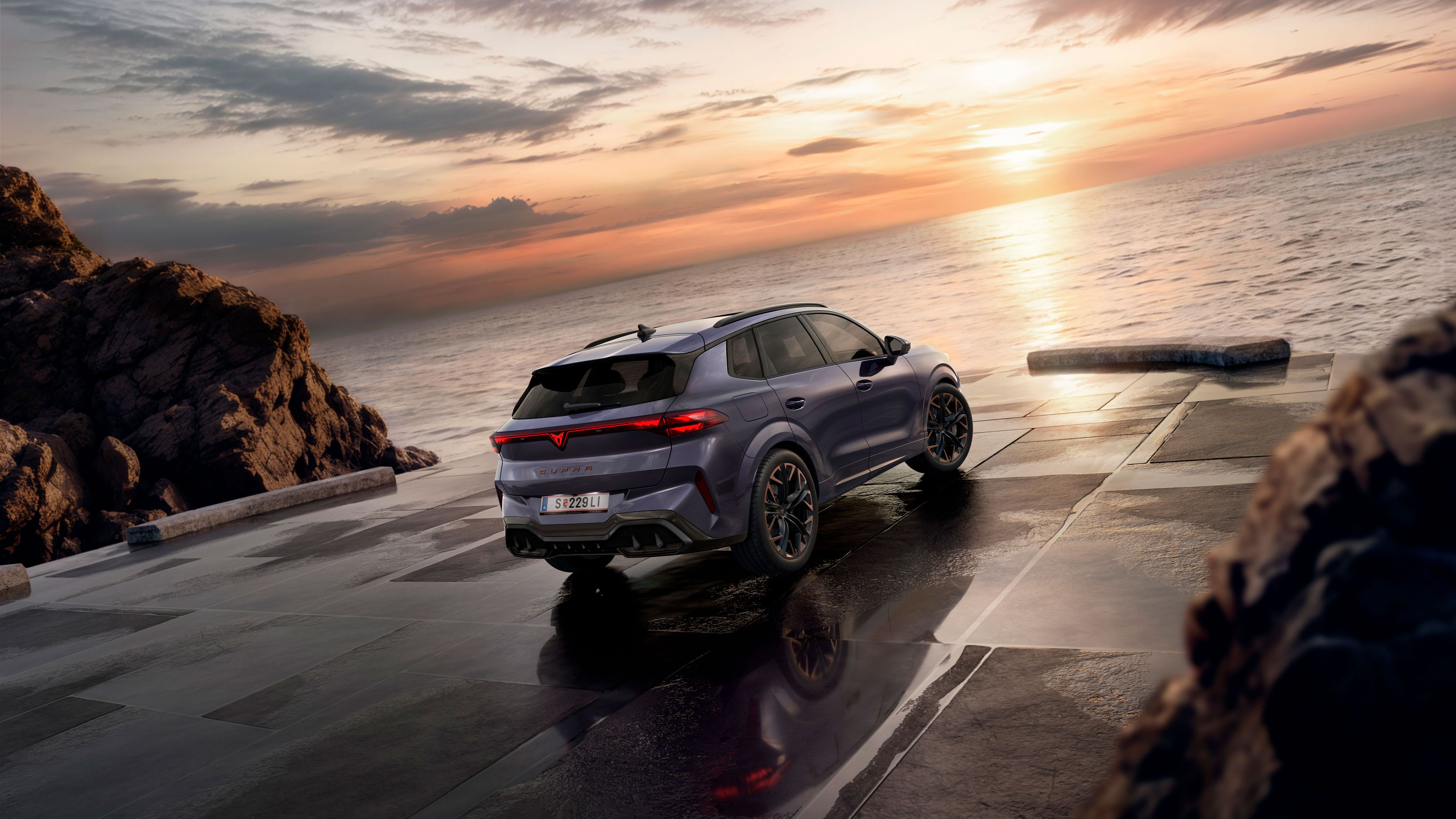 Ein CUPRA Terramar parkt zwischen Klippen am Meer. 