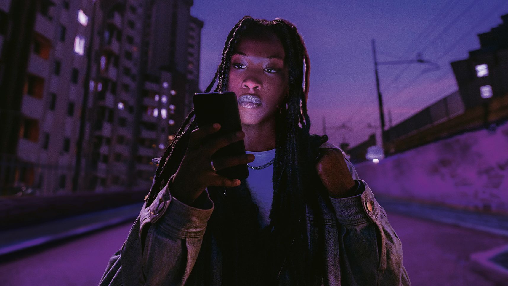 Frau blickt auf ihr Smartphone, das sie in der Hand hält.