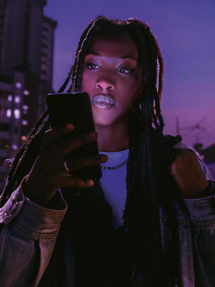 Frau blickt auf ihr Smartphone, das sie in der Hand hält.