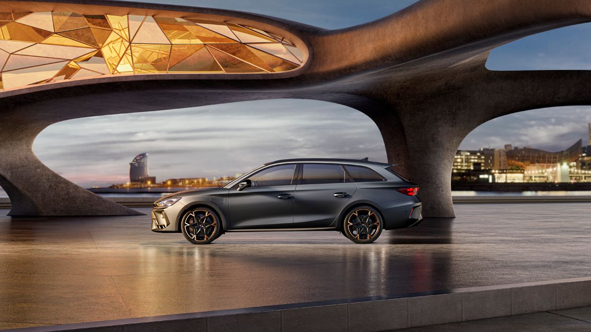 Seitenansicht eines grauen CUPRA Leon SP Kombi, der in einem modernen Parkhaus parkt.