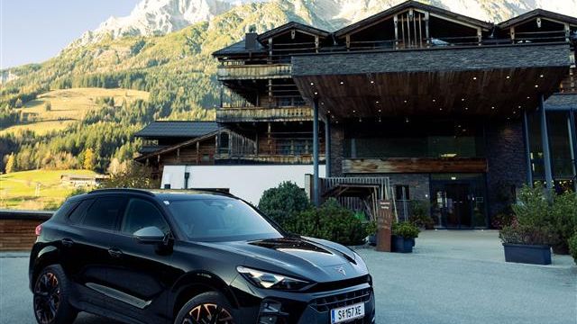 CUPRA Terramar vor dem PURADIES Gebäude mit Bergen im Hintergrund