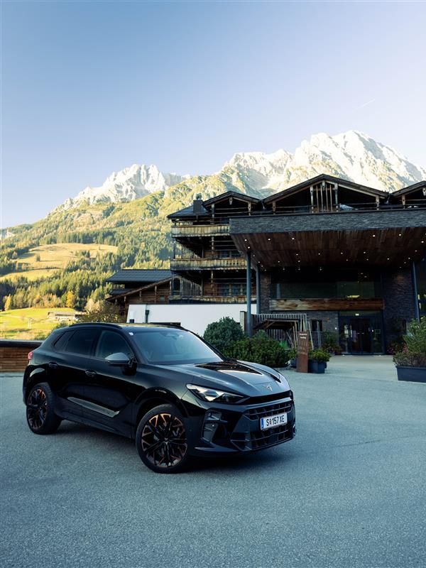CUPRA Terramar vor dem PURADIES Gebäude mit Bergen im Hintergrund