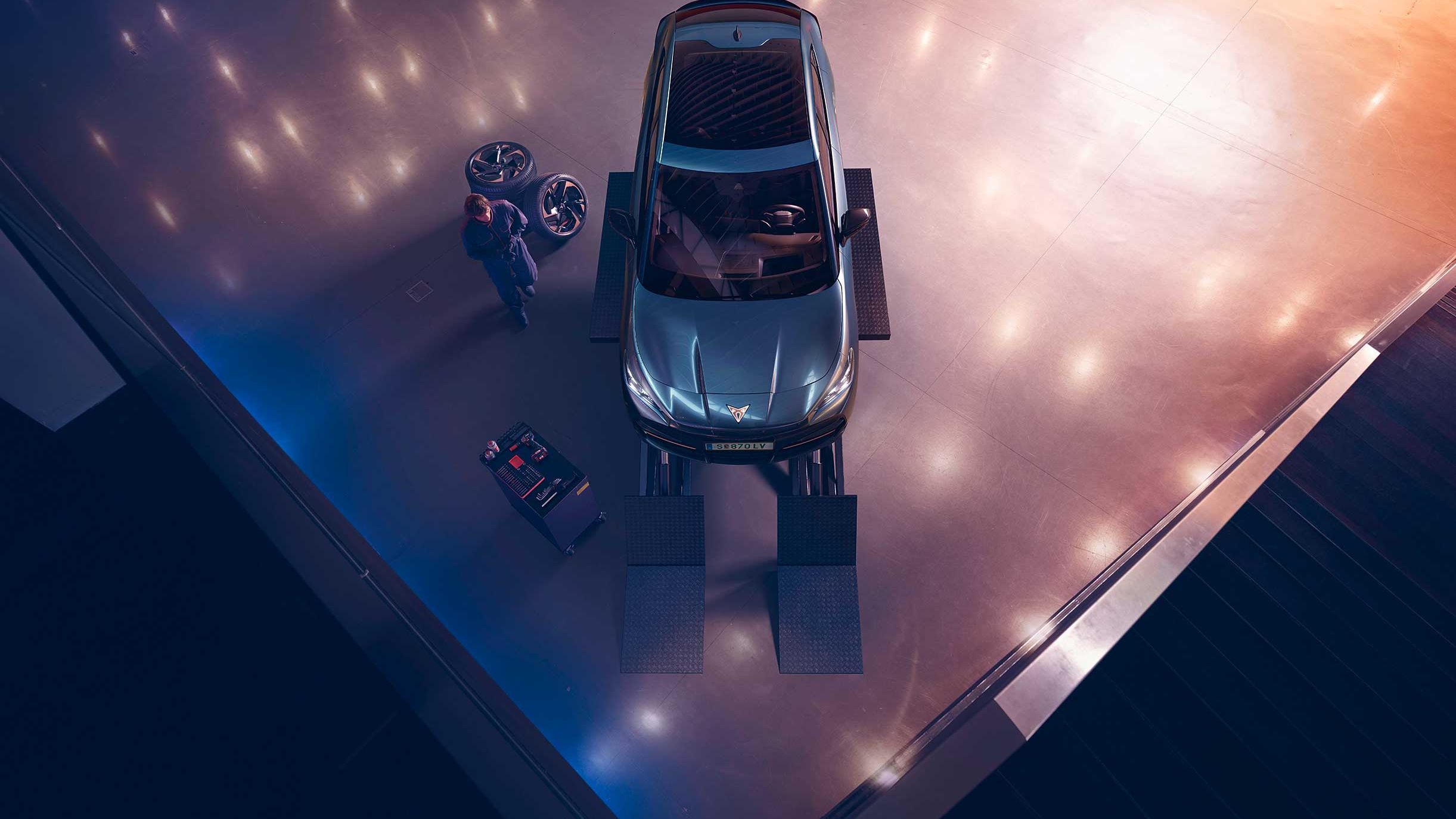 Blick von oben auf einen CUPRA Formentor. Neben dem Fahrzeug ein CUPRA Techniker mit Diagnosegerät.