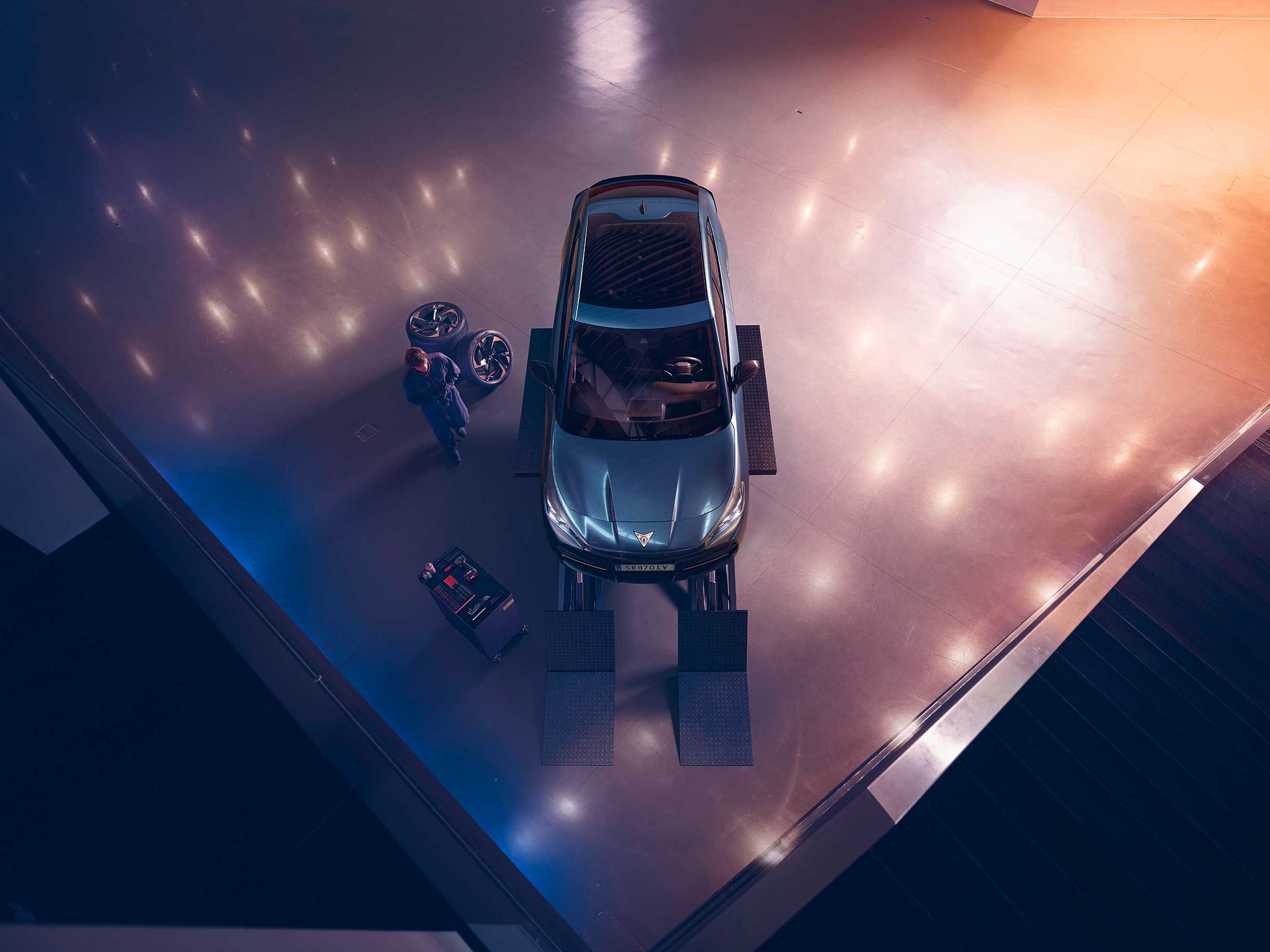 Blick von oben auf einen CUPRA Formentor. Neben dem Fahrzeug ein CUPRA Techniker mit Diagnosegerät.